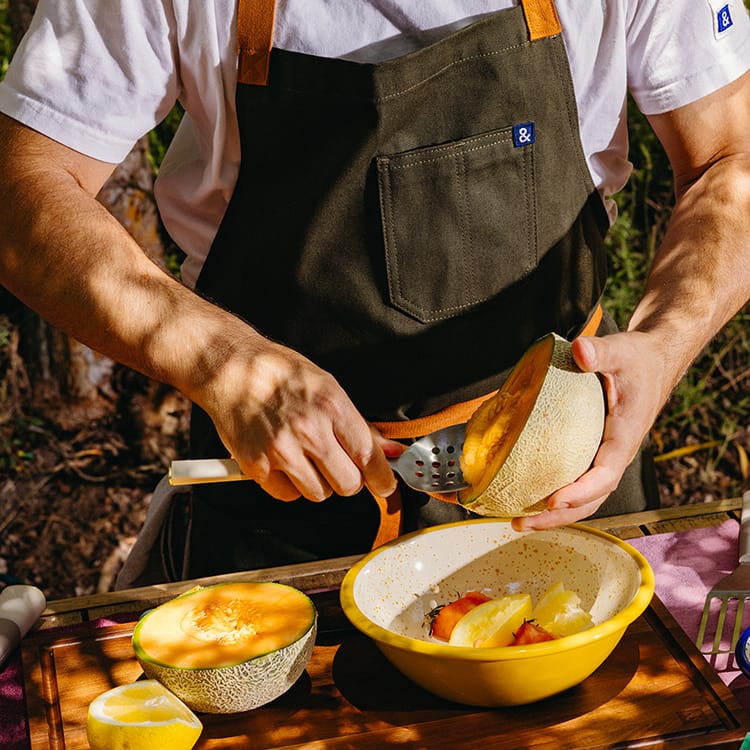 Iconic. Classic. Timeless. Nothing like our fan-favorite olive apron body with brand-new cider straps and a navy ampersand to remind you of the natural colorways of Summertime grillin' in the trees by the lake.